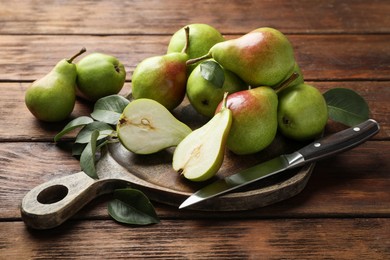 Photo of Fresh ripe pears and knife on wooden table, closeup