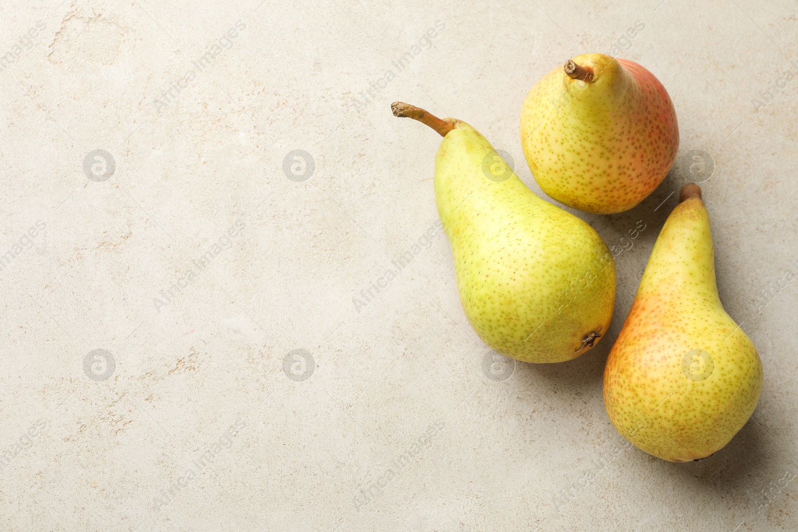Fresh ripe pears on light grey table, flat lay. Space for text Photo of Fresh ripe pears on light grey table, flat lay. Space for text