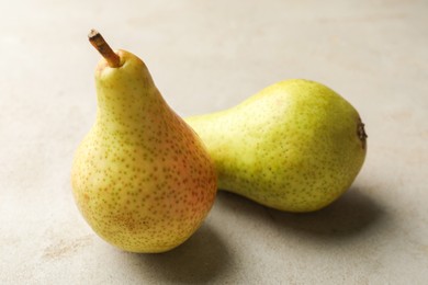 Photo of Fresh ripe pears on light grey table, closeup