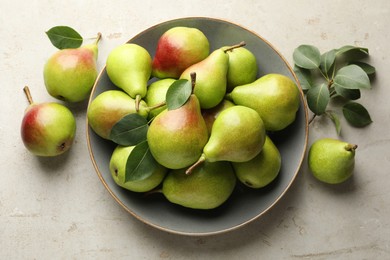 Photo of Fresh ripe pears and green leaves on light grey table, flat lay
