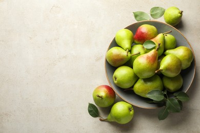Photo of Fresh ripe pears and green leaves on light grey table, flat lay. Space for text