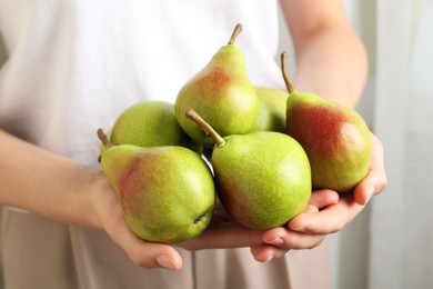 Photo of Woman with fresh ripe pears indoors, closeup