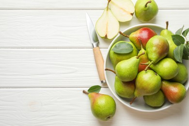 Photo of Fresh ripe pears, knife and green leaves on white wooden table, flat lay. Space for text
