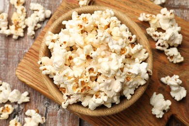 Photo of Tasty popcorn on wooden table, flat lay