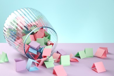 Photo of Bright paper pieces in glass jar on color background, closeup. Space for text
