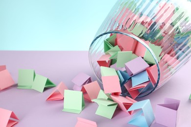 Photo of Bright paper pieces in glass jar on color background, closeup