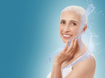 Image of Woman with smooth skin and water splashes against blue gradient background. Space for text
