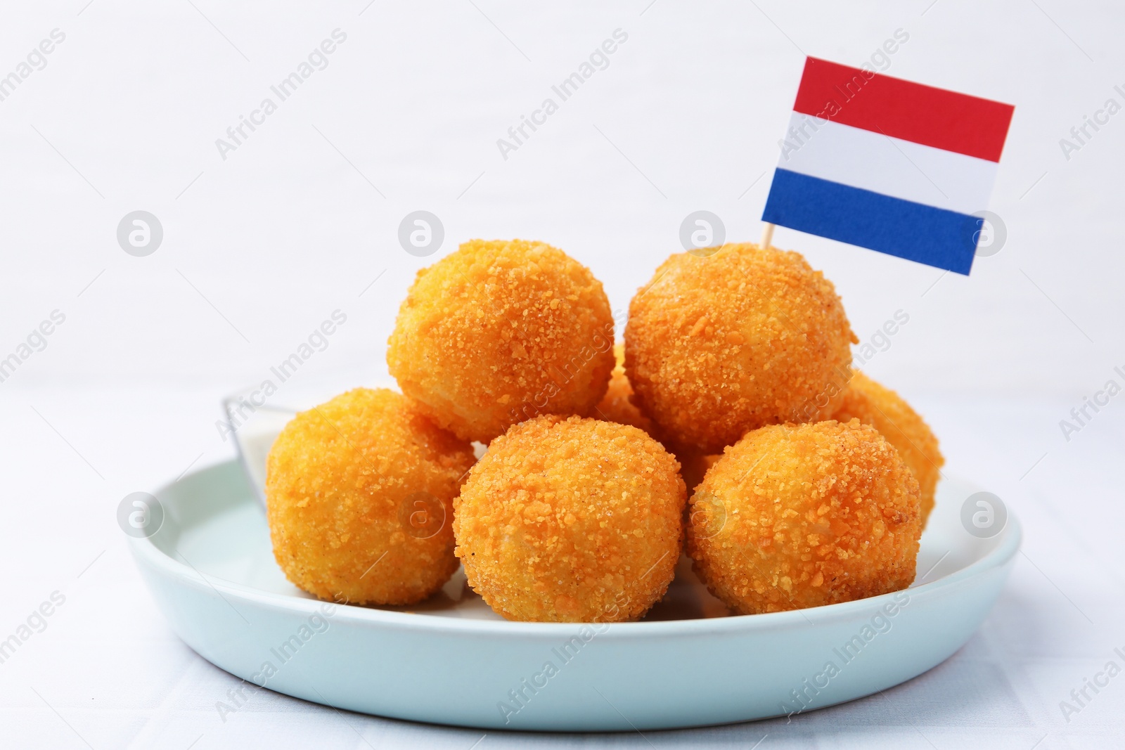 Delicious fried croquette balls and flag of Netherlands on light table, closeup Photo of Delicious fried croquette balls and flag of Netherlands on light table, closeup