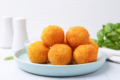 Photo of Delicious fried croquette balls on light tiled table, closeup