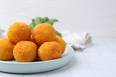 Photo of Delicious fried croquette balls on light tiled table, closeup. Space for text