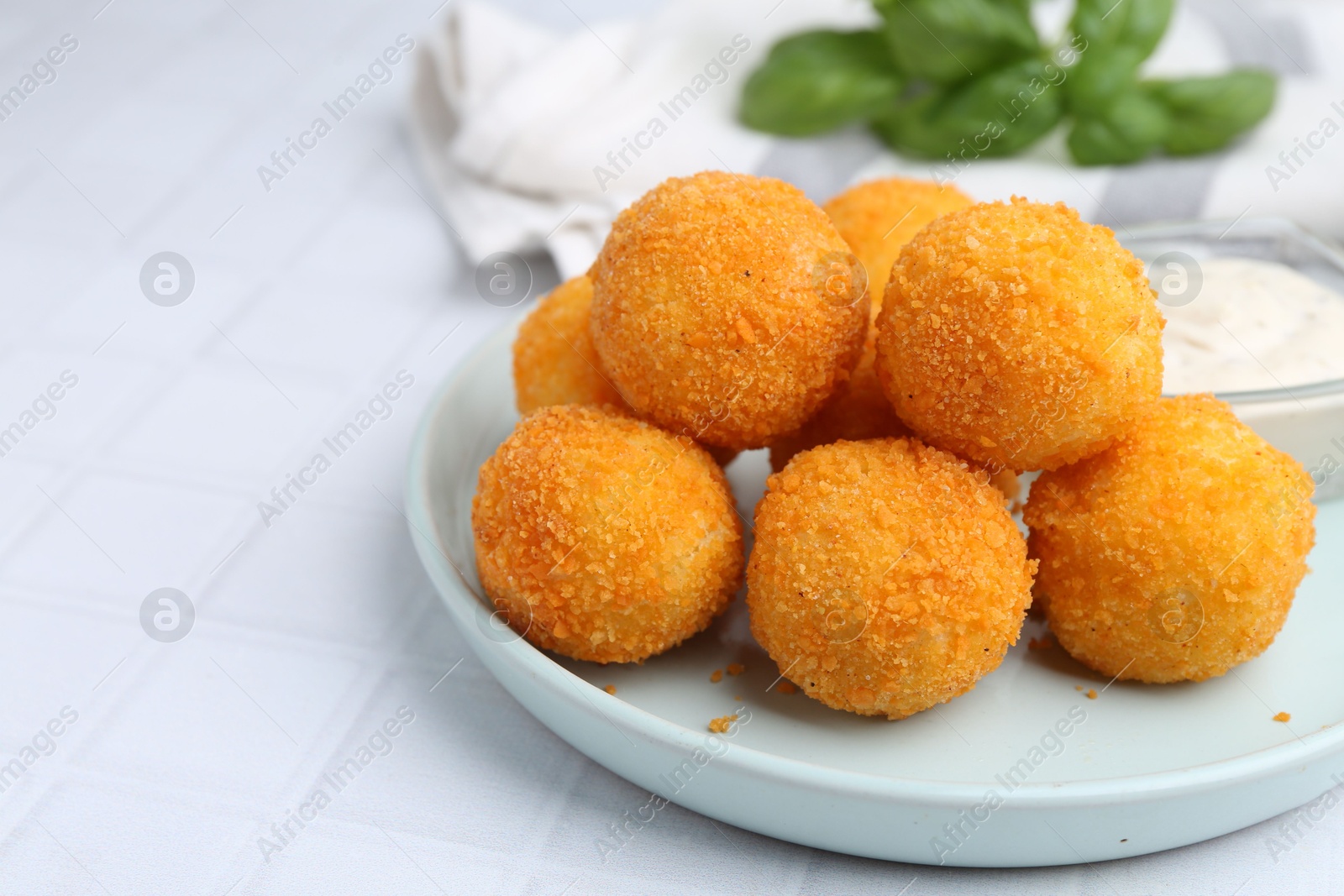 Photo of Delicious fried croquette balls on light tiled table, closeup