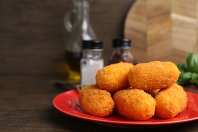 Photo of Delicious fried croquettes on wooden table, closeup