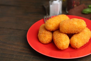 Photo of Many delicious fried croquettes on wooden table, closeup