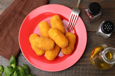Photo of Delicious fried croquettes served on wooden table, flat lay