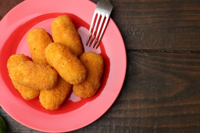 Photo of Delicious fried croquettes served on wooden table, flat lay