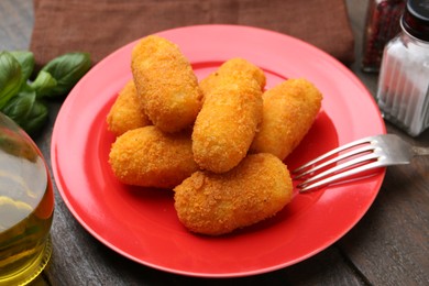 Photo of Delicious fried croquettes served on wooden table, closeup
