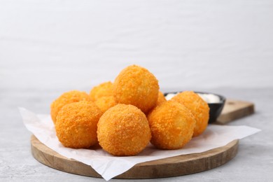 Photo of Delicious fried croquette balls on gray table, closeup