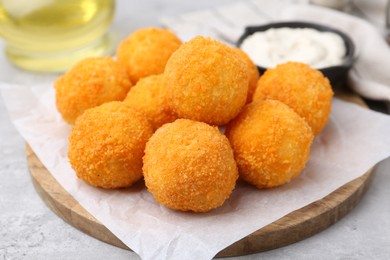 Photo of Delicious fried croquette balls on gray table, closeup