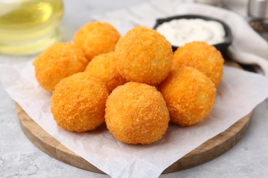 Photo of Delicious fried croquette balls on gray table, closeup