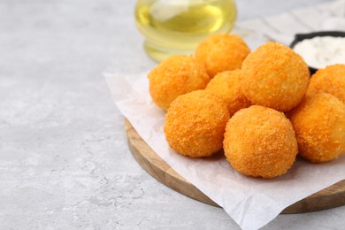 Photo of Delicious fried croquette balls on gray textured table, closeup. Space for text