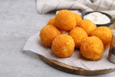 Photo of Delicious fried croquette balls on gray textured table, closeup