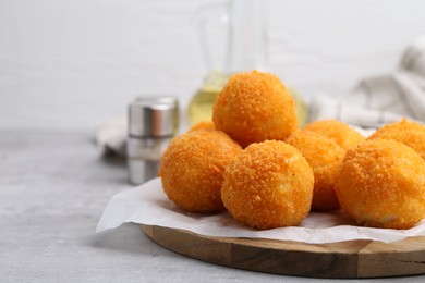 Photo of Delicious fried croquette balls on gray textured table, closeup