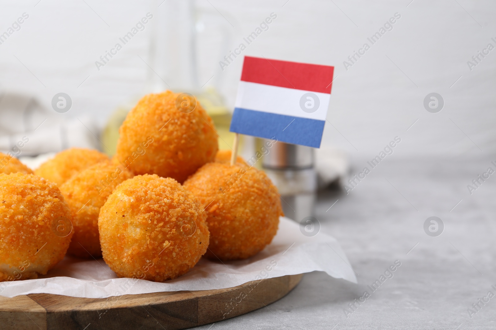 Delicious fried croquette balls and flag of Netherlands on gray table, closeup Photo of Delicious fried croquette balls and flag of Netherlands on gray table, closeup