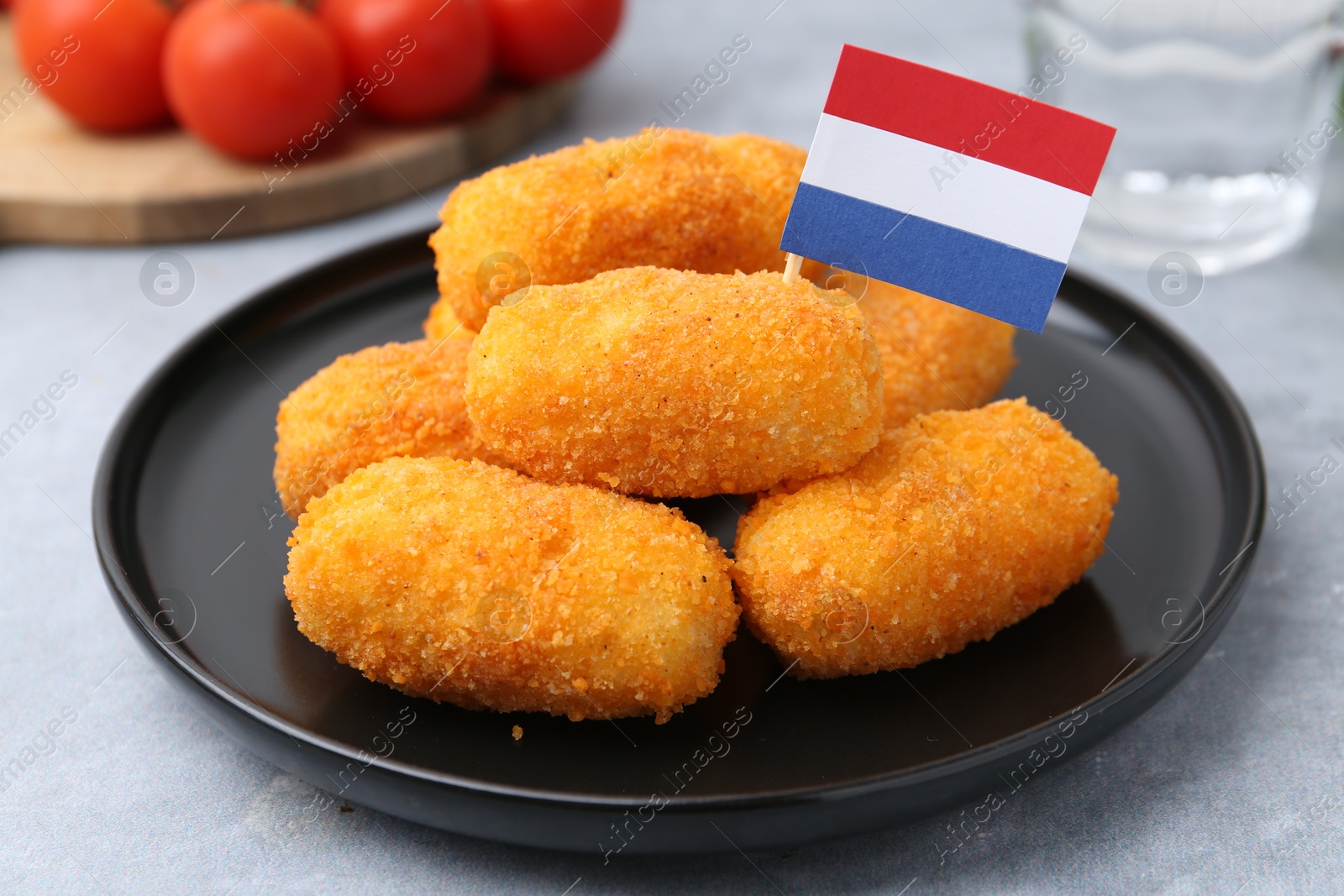 Delicious fried croquettes and flag of Netherlands on gray table, closeup Photo of Delicious fried croquettes and flag of Netherlands on gray table, closeup