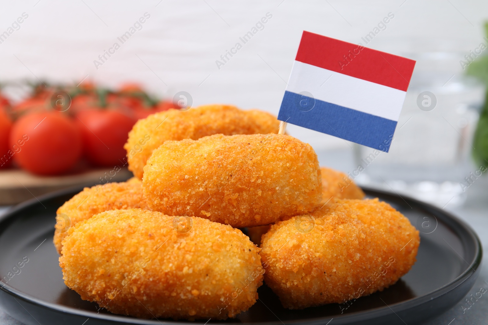 Delicious fried croquettes and flag of Netherlands on table, closeup Photo of Delicious fried croquettes and flag of Netherlands on table, closeup
