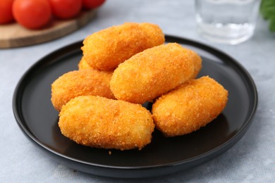 Photo of Delicious fried croquettes on gray table, closeup