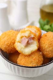 Photo of Delicious fried croquette balls in bowl on table, closeup