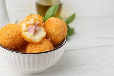 Photo of Delicious fried croquette balls in bowl on white wooden table, closeup. Space for text