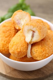Photo of Delicious fried croquettes in bowl on table, closeup