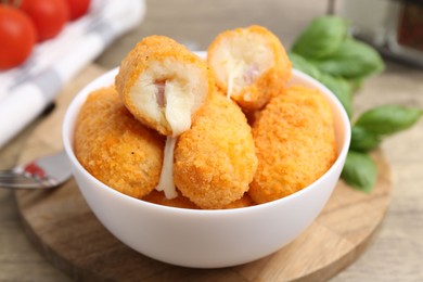 Photo of Delicious fried croquettes in bowl on table, closeup