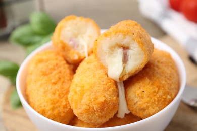 Photo of Delicious fried croquettes in bowl on table, closeup