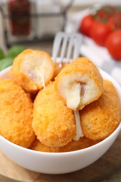 Photo of Delicious fried croquettes in bowl on table, closeup