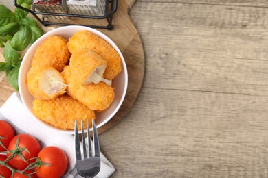 Photo of Delicious fried croquettes in bowl, tomatoes and spices on wooden table, flat lay. Space for text