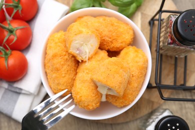 Photo of Delicious fried croquettes in bowl, tomatoes and spices on table, flat lay