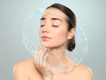 Image of Woman with smooth skin and water splash on grey background