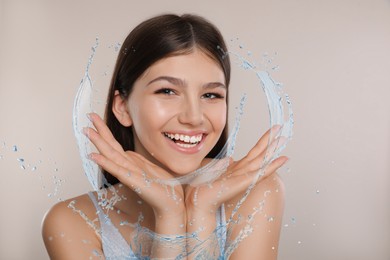 Image of Woman with smooth skin and water splashes on grey background