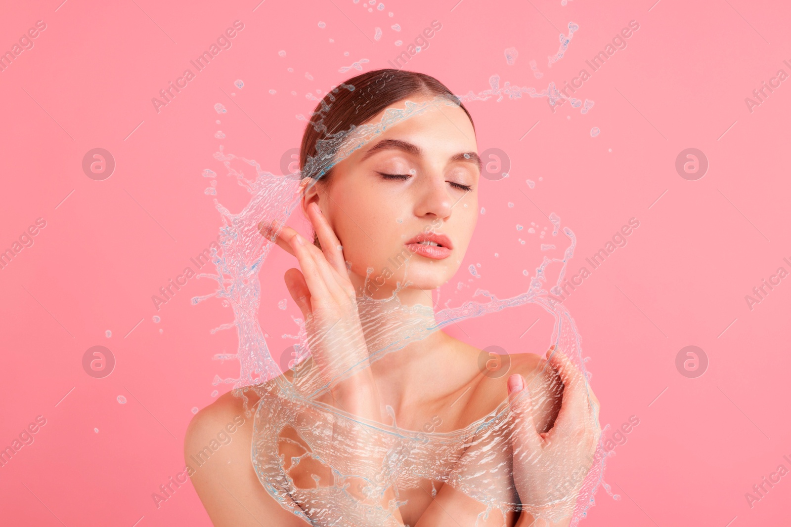 Young woman with smooth skin and water splashes on pink background Image of Young woman with smooth skin and water splashes on pink background