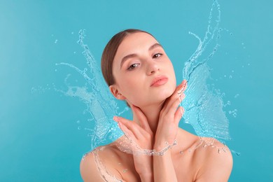 Image of Young woman with smooth skin and water splashes on light blue background