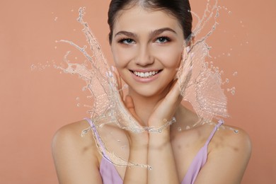 Image of Woman with smooth skin and water splashes against dark beige background
