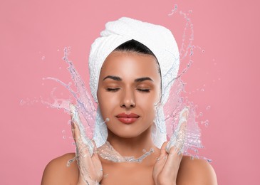 Image of Woman washing face with cleansing foam and water splashes on pink background