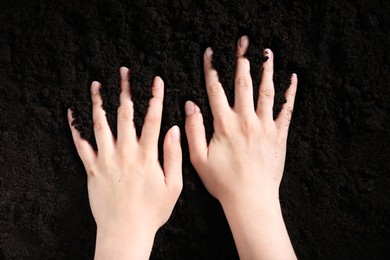 Photo of Woman touching fresh soil, top view. Organic matter