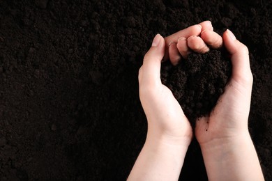 Photo of Woman with pile of fresh soil, top view