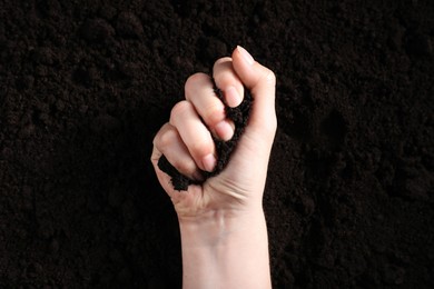 Photo of Woman with pile of fresh soil, top view