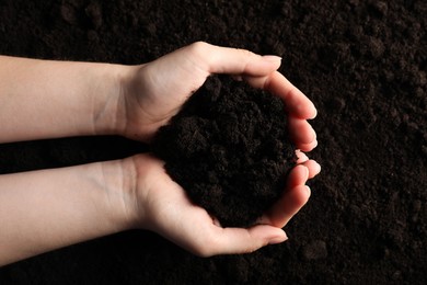 Photo of Woman with pile of fresh soil, top view