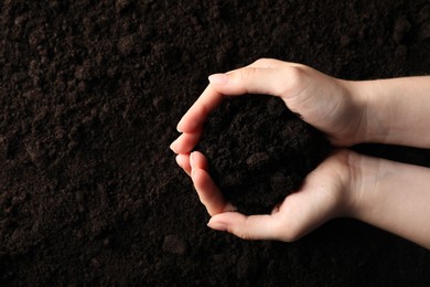 Photo of Woman with pile of fresh soil, top view