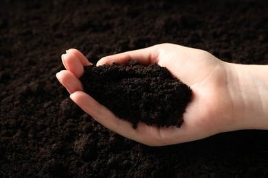 Photo of Woman with pile of fresh soil, closeup